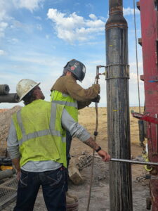 Water well drilling crew working on steel well casing in Idaho