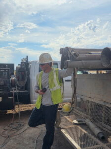 Idaho well driller examining material brought up during water well drilling