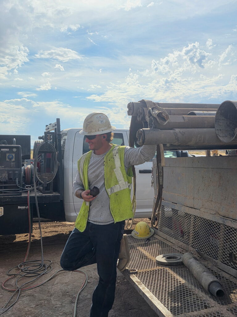 Idaho well driller examining material brought up during water well drilling
