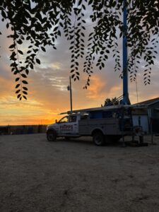 Phipps Water Solutions well service truck at an Idaho home at sunset
