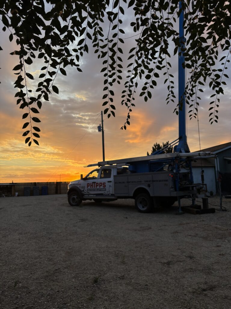 Phipps Water Solutions well service truck at an Idaho home at sunset