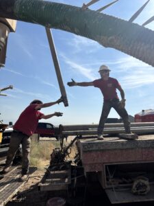 Water well drilling crew handling drill pipe at an Idaho jobsite