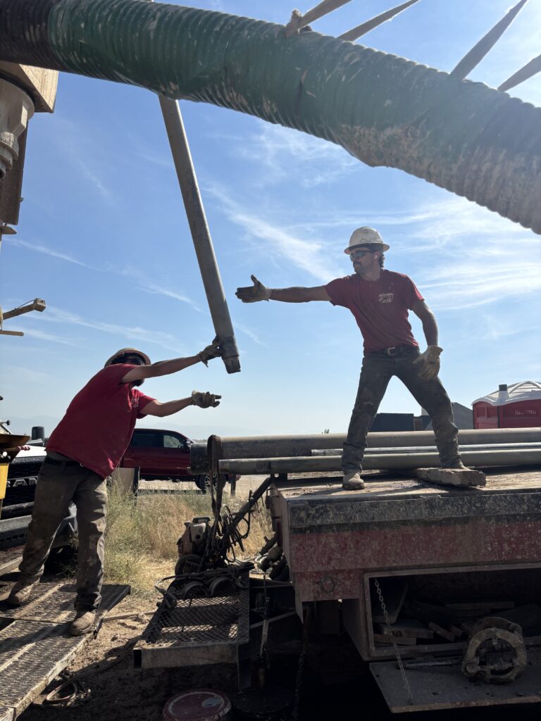 Water well drilling crew handling drill pipe at an Idaho jobsite